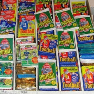 May include: A collection of vintage football trading cards featuring various players and teams. The cards are in a variety of colours, including red, blue, green, and yellow. The cards are arranged in rows and columns, and some of the cards have the word "Football" printed on them.