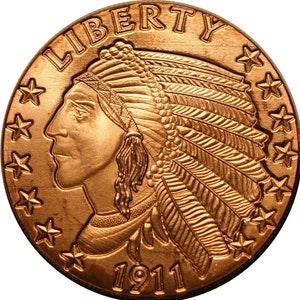 May include: A gold-colored coin with the image of an American Indian wearing a headdress and the words "LIBERTY" and "1911" on the front.