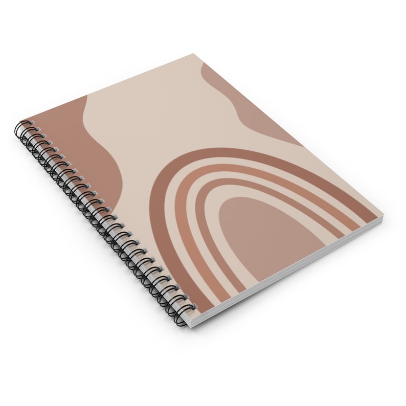 May include: A spiral bound notebook with a beige cover featuring an abstract design of overlapping arches in shades of brown.