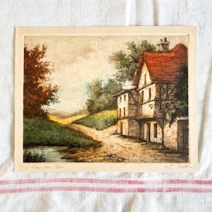 May include: A vintage watercolor painting of a white house with a red roof in a rural setting. The house is surrounded by trees and a dirt road leads to it. The painting is signed "J. Bott" and titled "L'Oie au Bois".