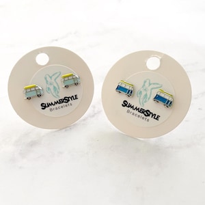 May include: A pair of blue and yellow enamel camper van stud earrings on white cards with the text "SummerStyle Bracelets".