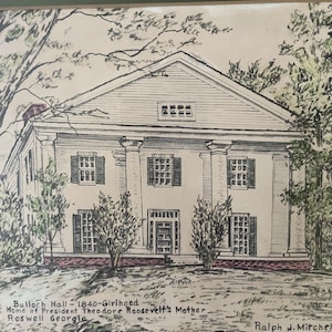 May include: A framed pen and ink drawing of Bulloch Hall, the childhood home of Theodore Roosevelt's mother, in Roswell, Georgia. The artwork depicts a stately white building with columns, shutters, and surrounding trees. The text "Bulloch Hall" and other details are visible.