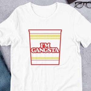May include: White t-shirt with a red and yellow graphic of a ramen noodle cup with the text "I'm Gangsta".
