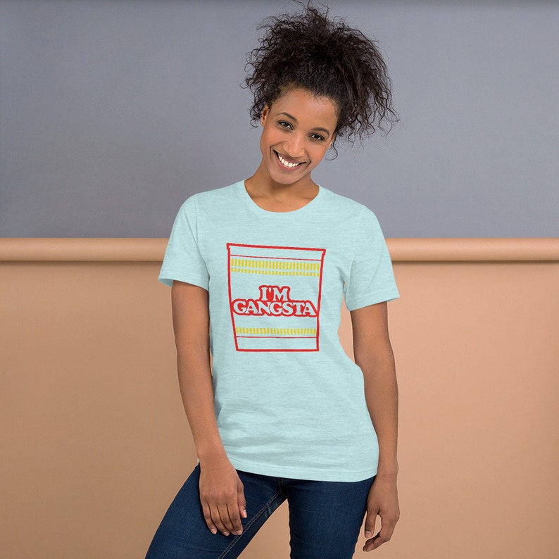 May include: A light blue t-shirt with a graphic of a ramen noodle cup that says "I'm Gangsta" in red letters.