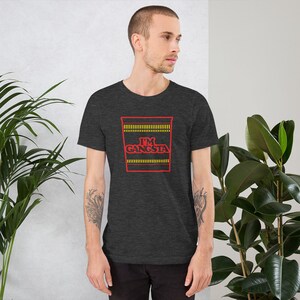 May include: A dark heather grey t-shirt with a red and yellow graphic of a ramen noodle cup with the text "I'M GANGSTA".