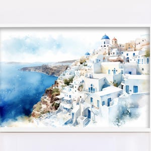 A framed watercolor painting depicting a picturesque coastal town with white buildings and blue roofs, overlooking the ocean.