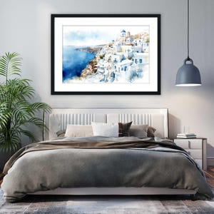 a bedroom with a large bed, a framed painting of a coastal town, and a potted plant.