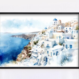 The image is a framed watercolor painting depicting a picturesque coastal town with white buildings and blue roofs, overlooking the ocean.