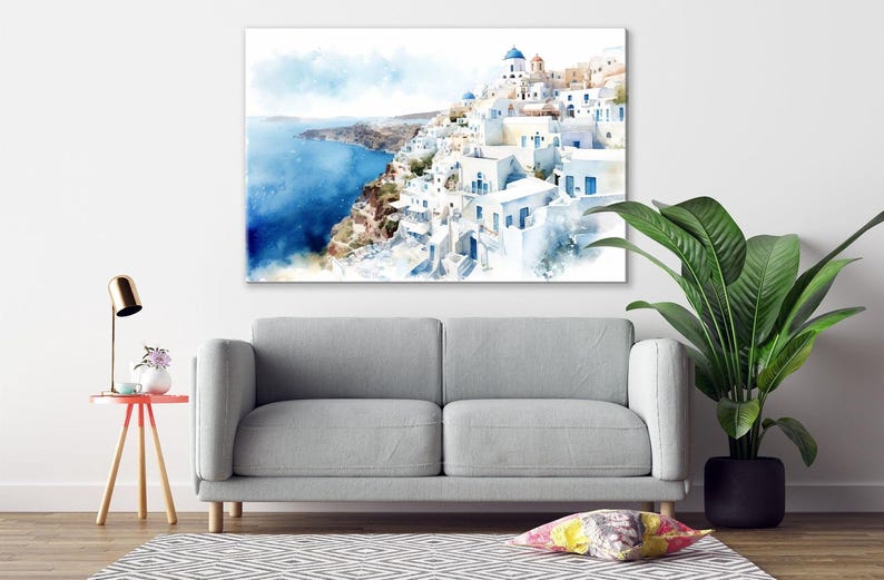 a living room with a gray sofa, a small table with a lamp, and a large painting of a coastal town with white buildings and blue roofs.
