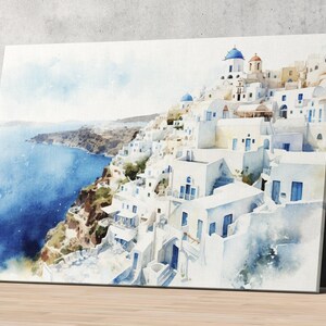 The image is a watercolor painting depicting a picturesque coastal town with white buildings and blue domes overlooking the ocean.