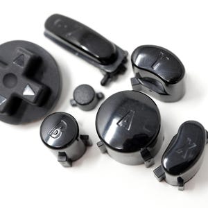 Könnte beinhalten: Eine Ansammlung schwarzer Gamecontroller-Tasten und ein Steuerkreuz auf weißem Hintergrund. Die Tasten sind mit A, B, X und Y beschriftet, zusammen mit einem Steuerkreuz und einer langen Taste.