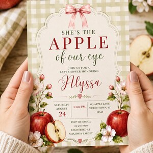 Może przedstawiać: Prostokątne zaproszenie na baby shower z jasnozielonym tłem w kratkę, r&oacute;żową kokardką na g&oacute;rze i ilustracjami czerwonych jabłek. Tekst brzmi: SHE'S THE APPLE of our eye, JOIN US FOR A BABY SHOWER HONORING Alyssa, SATURDAY AUGUST 24, 2:00 PM, 123 APPLE LANE SWEET TOWN, ST 12345, RSVP TO JESSICA 123-456-7890, REGISTERED AT AMAZON & TARGET.