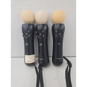 May include: Three black Sony PlayStation Move motion controllers, each featuring a spherical light-up top, a central navigation button with the PlayStation logo, and standard action buttons including triangle, circle, cross, and square symbols.