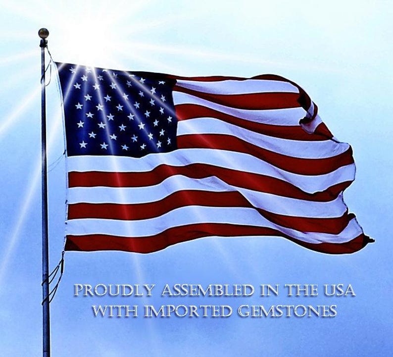 a flag of the United States waving in the wind, with a bright sun shining behind it.