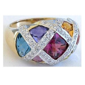 A gold ring with a diamond-encrusted design, featuring a variety of colorful gemstones including blue, purple, pink, and yellow stones.