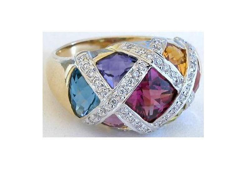 A gold ring with a diamond-encrusted design, featuring a variety of colorful gemstones including blue, purple, pink, and yellow stones.