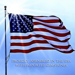 a flag of the United States waving in the wind, with a bright sun shining behind it.