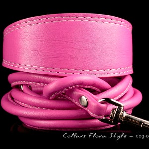 Puede incluir: Un collar de perro de cuero rosa con costuras blancas y un cierre plateado. El collar está enrollado y el cierre es visible. El texto "Collars flora Style - dog-collar.shop" es visible en la parte inferior de la imagen.