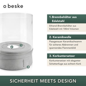 May include: A gray concrete candle holder with a glass cylinder and a cork base. The candle holder is labeled with the numbers 1, 2, and 3. The text "SICHERHEIT MEETS DESIGN" is printed below the candle holder.