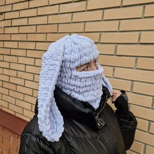 Puede incluir: Un pasamonta&ntilde;as de punto azul claro con largas orejas de conejo. La cobertura facial est&aacute; hecha de un material suave y texturizado. El sombrero est&aacute; dise&ntilde;ado para cubrir la cabeza, el cuello y la cara, con aberturas para los ojos.