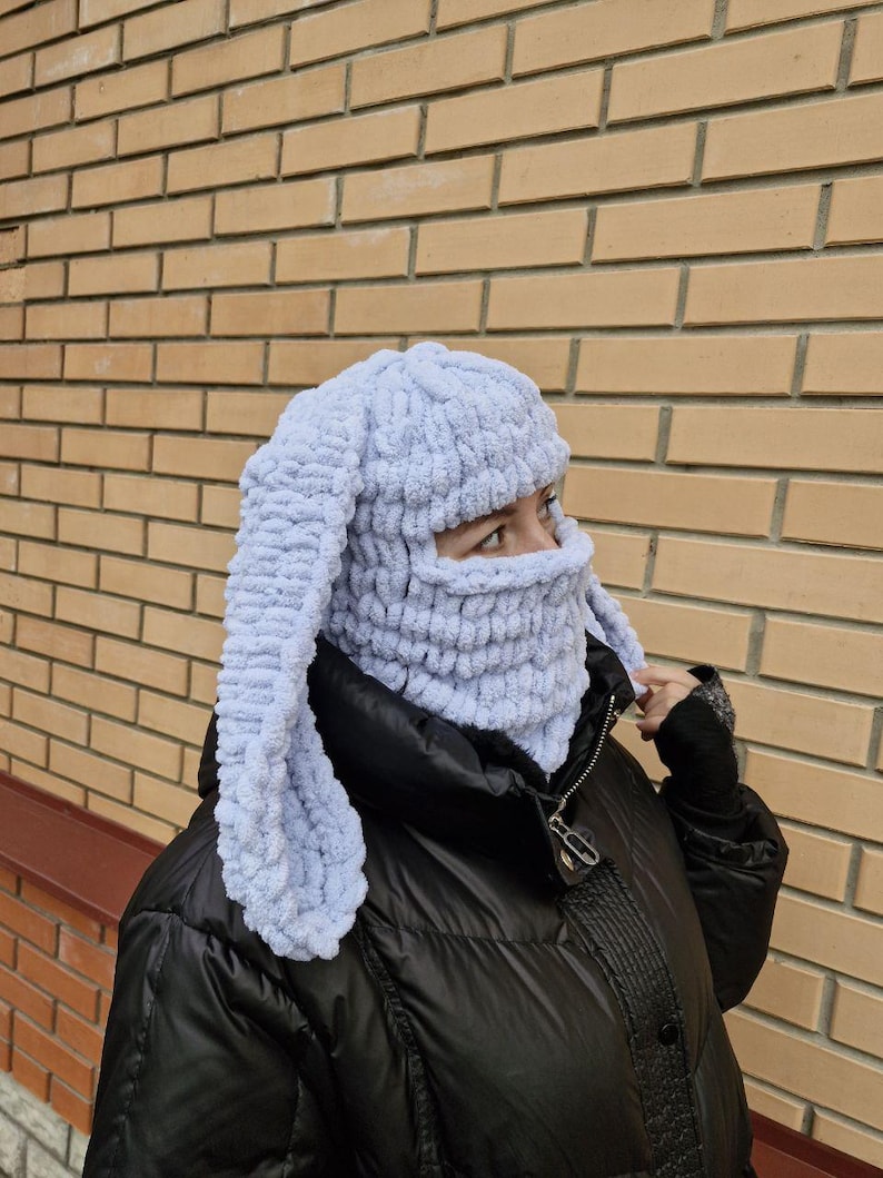 Puede incluir: Un pasamonta&ntilde;as de punto azul claro con largas orejas de conejo. La cobertura facial est&aacute; hecha de un material suave y texturizado. El sombrero est&aacute; dise&ntilde;ado para cubrir la cabeza, el cuello y la cara, con aberturas para los ojos.