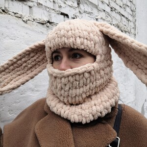 Puede incluir: Un pasamonta&ntilde;as beige tejido con largas orejas de conejo. La cobertura facial tiene una abertura para los ojos y la boca. El gorro est&aacute; hecho de un hilo grueso y suave y est&aacute; dise&ntilde;ado para mantener la cabeza y el cuello calientes.