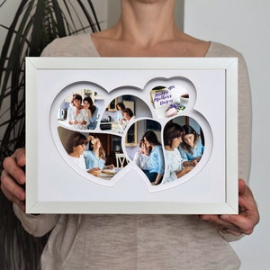 May include: White picture frame with a collage of photos inside. The photos are arranged in the shape of two hearts. The text "Happy Mother's Day" is visible in one of the photos.