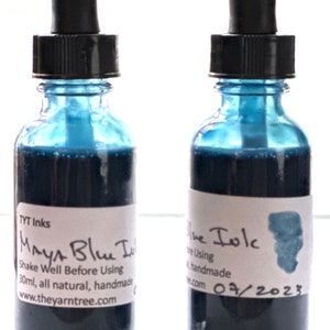 May include: Two small glass bottles with dropper tops filled with dark blue ink. The labels read "Maya Blue Ink" and "Blue Ink". The bottles are 30 ml and handmade.