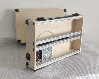 以下が含まれることがあります： 蓋付きのヒンジ付きの木製ボックスと、内部の電源。ボックスには3つの棚があり、明るい木材で作られています。ボックスが開いており、電源が見えます。
