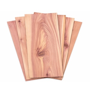 May include: A set of six rectangular cedar wood planks arranged in a fan shape. Each plank displays a distinct reddish-brown grain pattern with visible knots and natural wood textures, showcasing the organic variations in the wood surface.