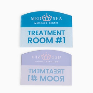 May include: Two blue and purple signs with rounded tops. The top sign says "MED SPA wellness center" and "TREATMENT ROOM #1". The bottom sign is reversed and says "WED SPA wellness center" and "TREATMENT ROOM #1".