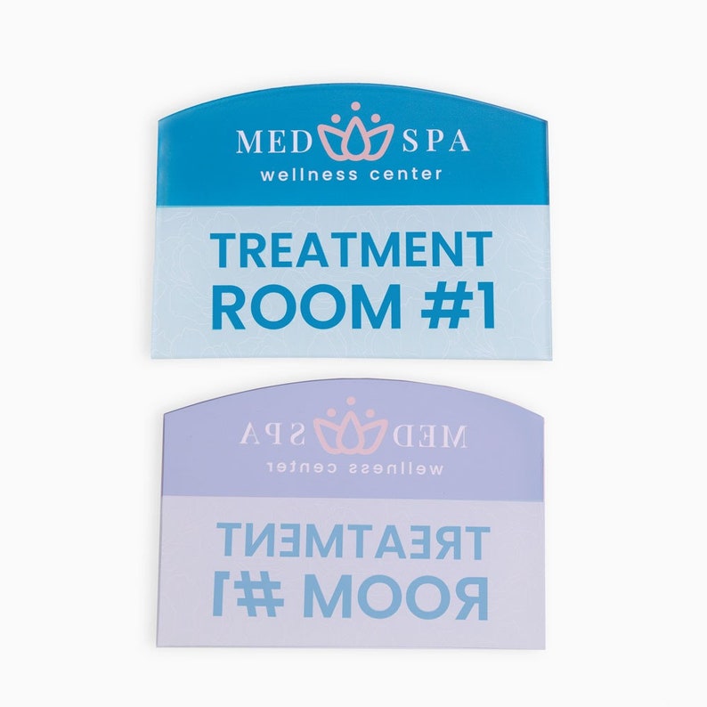 May include: Two blue and purple signs with rounded tops. The top sign says "MED SPA wellness center" and "TREATMENT ROOM #1". The bottom sign is reversed and says "WED SPA wellness center" and "TREATMENT ROOM #1".