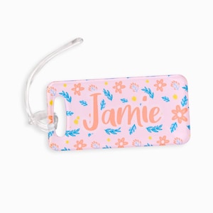 May include: Pink luggage tag with a floral pattern and the name "Jamie" in orange text.