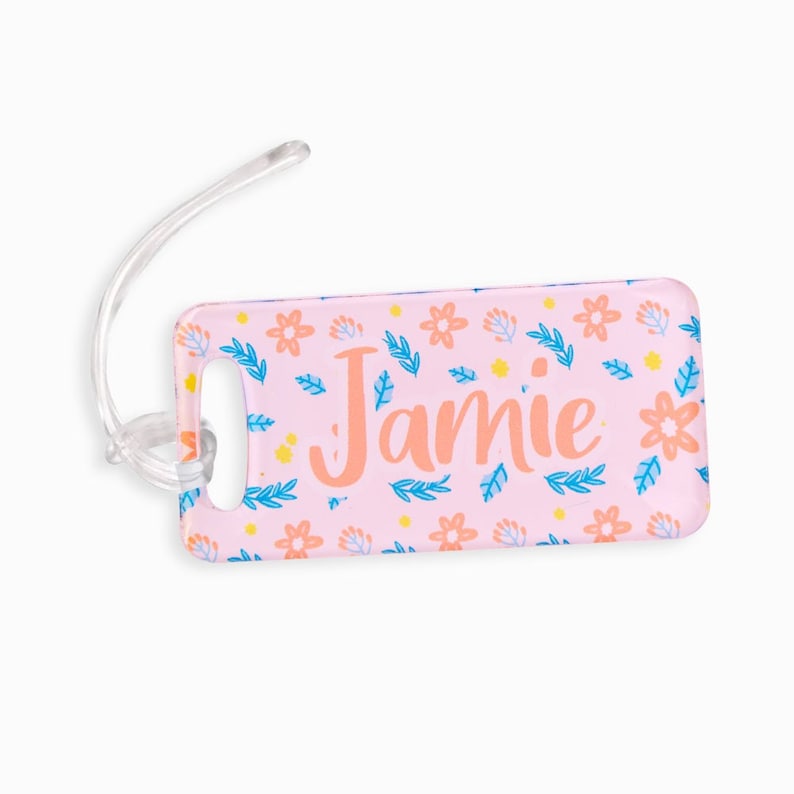 May include: Pink luggage tag with a floral pattern and the name "Jamie" in orange text.
