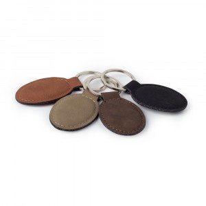 May include: Four oval-shaped leather keychains in brown, tan, green, and black. Each keychain has a silver metal ring.