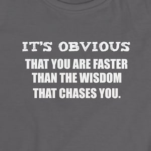 Puede incluir: Una camiseta gris con texto blanco que dice: "IT'S OBVIOUS THAT YOU ARE FASTER THAN THE WISDOM THAT CHASES YOU."