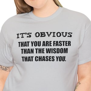 Puede incluir: Una camiseta gris con texto negro que dice "Es obvio que eres más rápido que la sabiduría que te persigue."