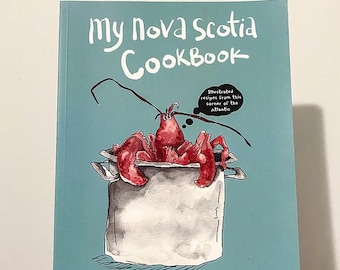 May include: A teal blue cookbook cover with the title "My Nova Scotia Cookbook" in white text. The cover features an illustration of a lobster in a pot with the text "Illustrated recipes from this corner of the Atlantic" in a speech bubble.