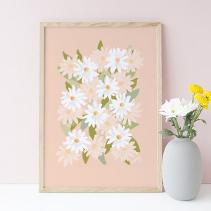 May include: A framed print of a floral illustration featuring a cluster of white and pink daisies on a light pink background. The print is in a light wood frame.