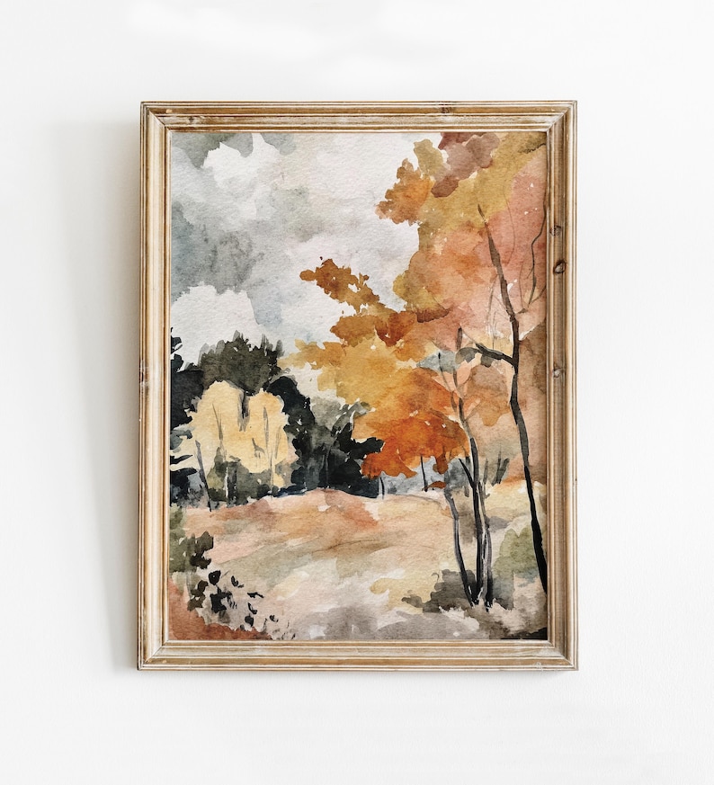 May include: Watercolor painting of a landscape with trees in autumn colors. The artwork features a wooden frame and a serene scene with shades of orange, yellow, and green. The sky is a mix of gray and white.