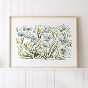 May include: A framed watercolor painting of blue flowers with green leaves on a white background.