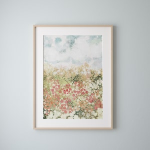 May include: A framed watercolor painting of a field of flowers in shades of pink, green, and white. The background is a light blue sky with clouds.