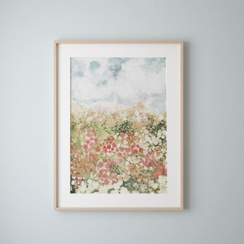 May include: A framed watercolor painting of a field of flowers in shades of pink, green, and white. The background is a light blue sky with clouds.