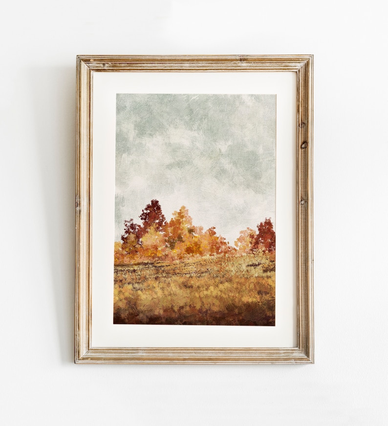 May include: A framed watercolour painting of an autumn landscape with a row of trees in shades of orange, yellow, and red against a cloudy sky.