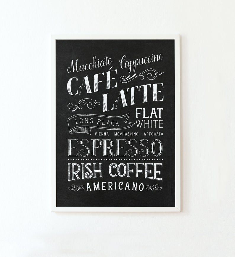 May include: Black and white chalkboard sign with a list of coffee drinks, including macchiato, cappuccino, cafe latte, long black, flat white, espresso, Irish coffee, and americano.