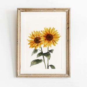 May include: A framed watercolor painting of two sunflowers with green stems and leaves on a white background.