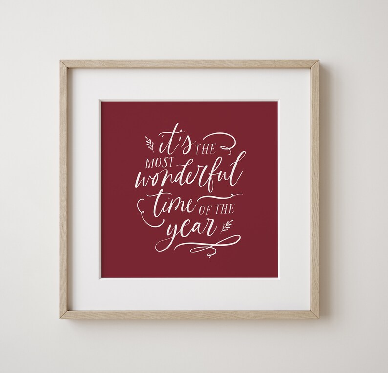 May include: A framed print with a red background and white text that reads "it's the most wonderful time of the year".
