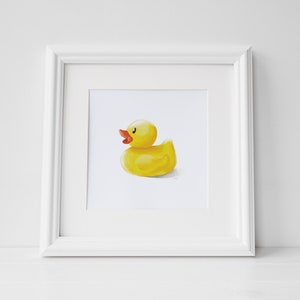May include: A framed illustration of a yellow rubber ducky with an orange beak and eyes. The ducky is facing to the right and is sitting on a white background.