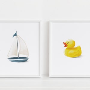 May include: Two framed prints, one with a blue sailboat and the other with a yellow rubber ducky.