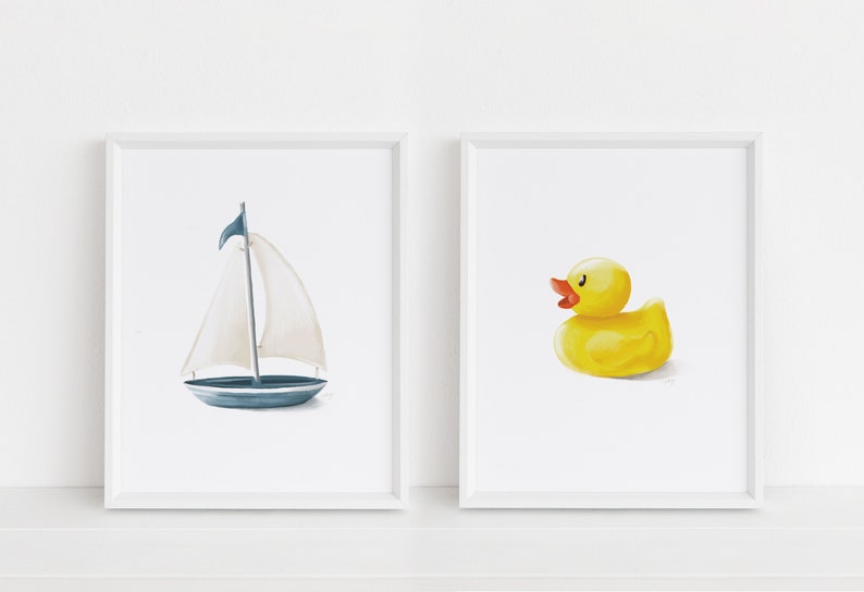 May include: Two framed prints, one with a blue sailboat and the other with a yellow rubber ducky.